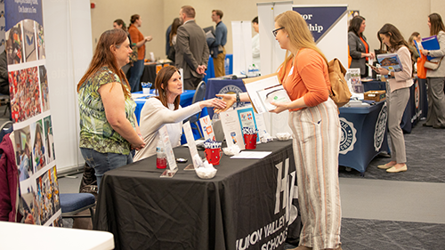 Student speaking to employer at spring education fair